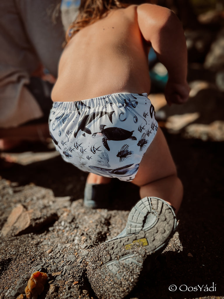 baby playing In a reusable swim diaper